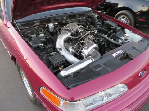 1992 Ford Crown Victoria - The engine bay of a red 1992 Ford Crown Victoria features a prominent supercharger and intake system.