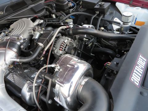1992 Ford Crown Victoria - Close-up view of a modified engine bay a prominent supercharger and custom intake system.