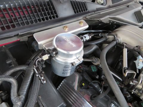 1992 Ford Crown Victoria - Aftermarket oil catch can installed in an engine bay, with handwritten notes on the can.
