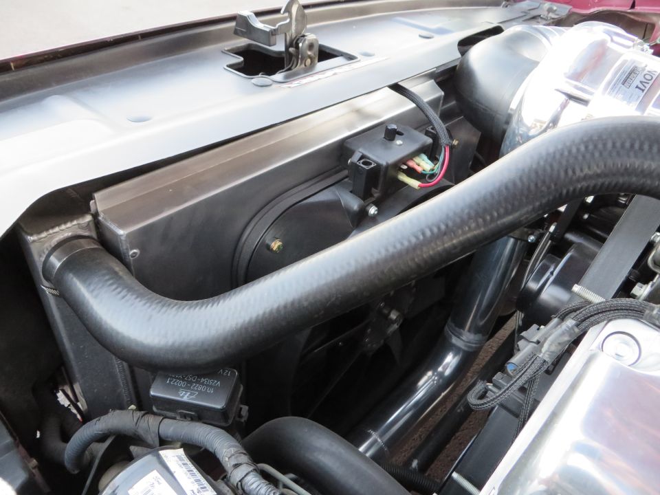 Engine bay showing a supercharger, hoses, and electrical components