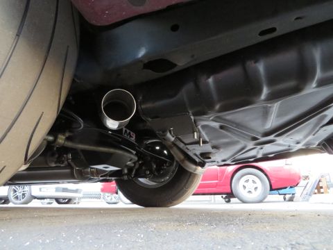 1992 Ford Crown Victoria - The underside of a vehicle reveals an exhaust pipe and a large tire, with another car partially visible in the background.