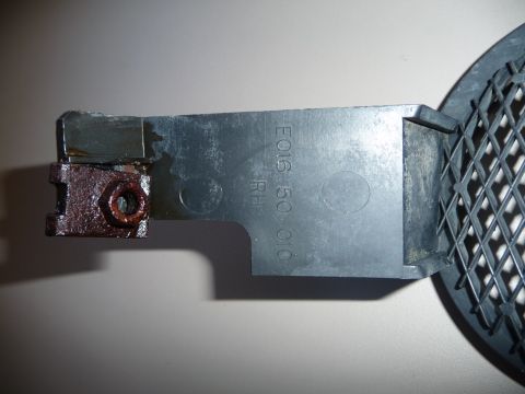 1993 Mazda MX-3 - A close-up view of a car part, showing a rusty bracket and embossed text.