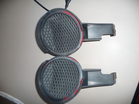 1993 Mazda MX-3 - Close-up of two automotive corner lights, each a protective grille and red accent paint.