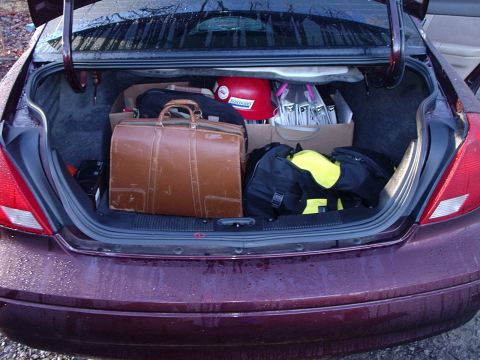 2000 Ford Taurus - The trunk of a car is filled with various bags and a helmet, suggesting a trip or move.