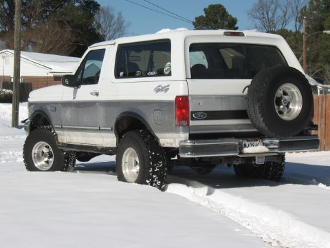 1994 Ford Bronco - 1994 Ford Bronco in snow, rear view showing spare tire and 4x4 decal.