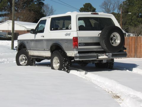 1994 Ford Bronco - This 1994 Ford Bronco is shown from the rear, navigating through a snowy landscape.