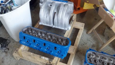 1988 Ford Bronco - Engine cylinder head and intake manifold are on a pallet, ready for assembly.