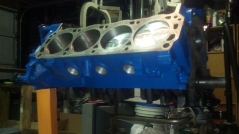 1988 Ford Bronco - A freshly painted blue engine block is mounted on an engine stand, ready for assembly.