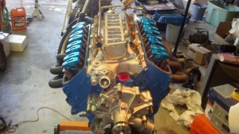 1988 Ford Bronco - Engine assembly with blue valve covers and intake manifold on an engine stand.