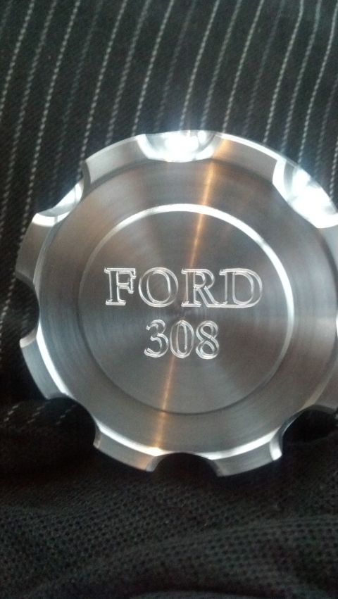 1988 Ford Bronco - Close-up of an aluminum engine part engraved with 'FORD 308'.