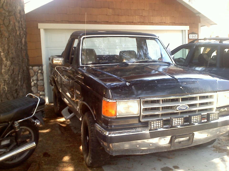 Black Ford truck, front view, with aftermarket lights and '4x4' badging