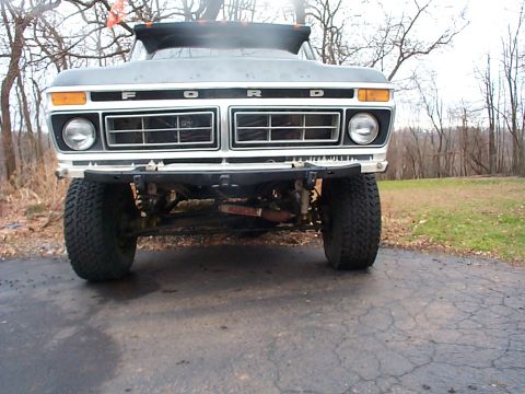 1979 Ford Bronco - The front grille of a 1979 Ford Bronco is visible, prominent F O R D lettering and large tires.