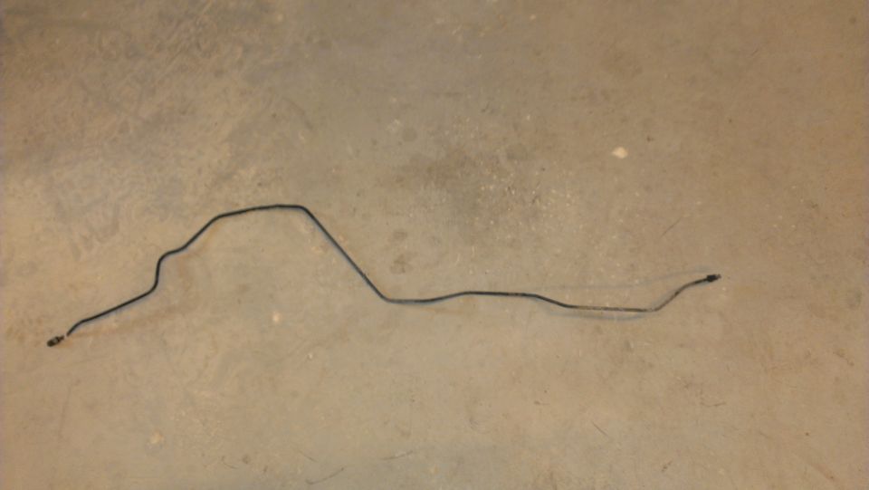 Bent metal brake line on a concrete floor