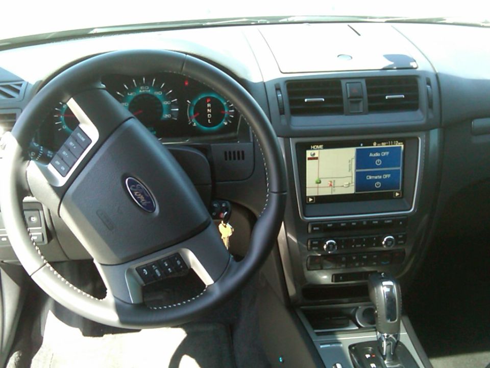 Car interior with a Ford steering wheel, dashboard, and infotainment screen
