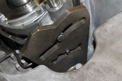 1995 Ford Bronco - Close-up of a vehicle's transfer case linkage mechanism, showing intricate metal components and guides.