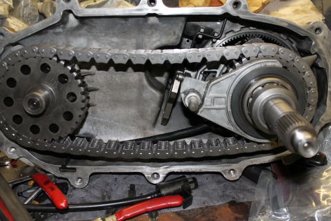 1995 Ford Bronco - Close-up view of the internal components of a transfer case, including the chain and gears, with a website logo visible.
