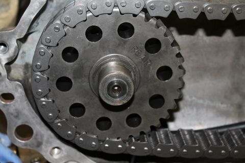 1995 Ford Bronco - This image shows a close-up view of a transfer case chain and gear, with the word 'REAR' stamped on the gear.