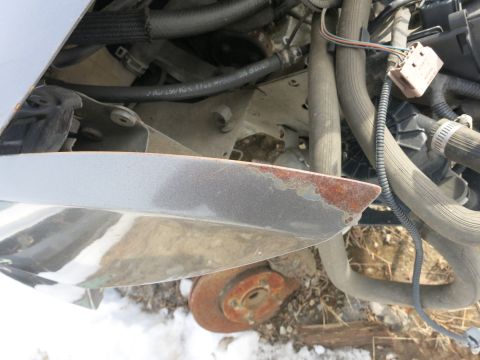 1991 Ford LTD Crown Victoria - The engine compartment of a vehicle shows various hoses, wiring, and some signs of rust on a body panel.