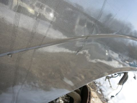 1991 Ford LTD Crown Victoria - Detail of a car fender showing a seam and minor damage.
