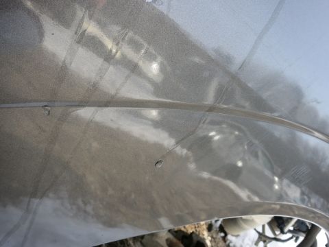 1991 Ford LTD Crown Victoria - A close-up view of a vehicle's fender shows minor imperfections and reflections.