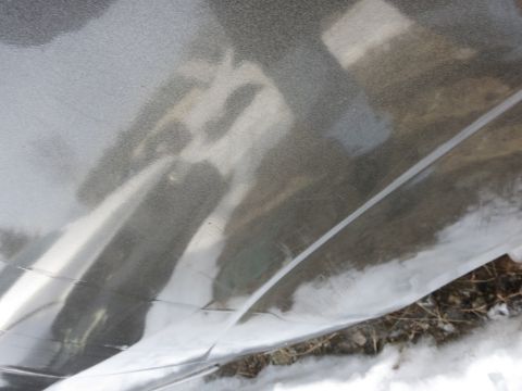 1991 Ford LTD Crown Victoria - The image shows a close-up of plastic sheeting covering the ground, with snow and dirt visible beneath it.