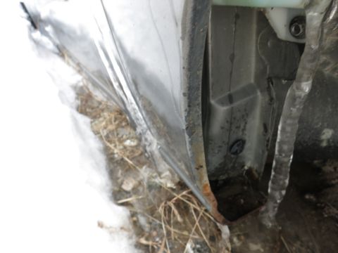 1991 Ford LTD Crown Victoria - Close-up of a car's door frame showing rust and icicles, suggesting damage or exposure to harsh weather.