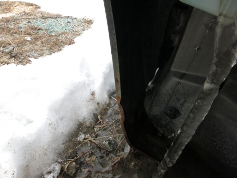 1991 Ford LTD Crown Victoria - Winter conditions have caused ice to form in the wheel well of a vehicle.