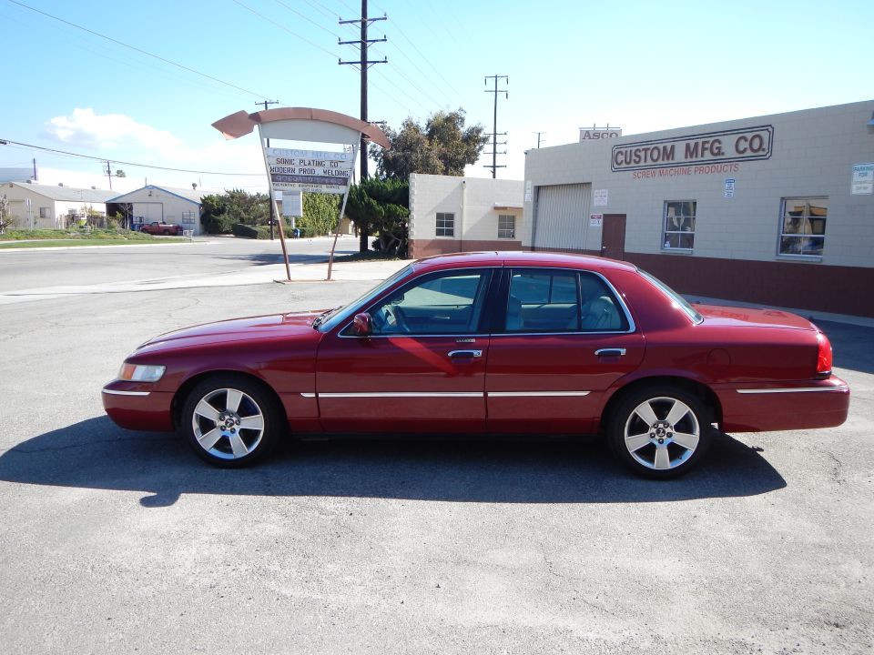 Red 2002 Mercury Grand Marquis sedan, side view, with five-spoke wheels