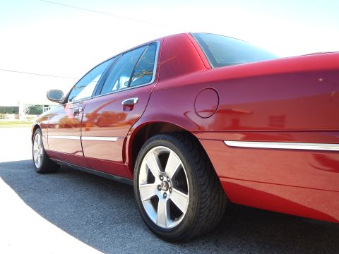 2002 Mercury Grand Marquis - This red sedan, identified as a 2002 Mercury Grand Marquis, is shown from a low rear three-quarter angle.