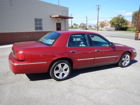 2002 Mercury Grand Marquis - This red sedan is seen from a 3/4 rear angle on a sunny day.
