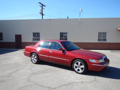 2002 Mercury Grand Marquis - A red 2002 Mercury Grand Marquis sedan is shown from the front three-quarter view in a parking lot.