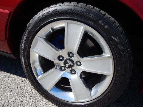 2002 Mercury Grand Marquis - Close-up of a wheel and tire assembly, showing the tire tread and wheel design. Blue brake caliper is visible.