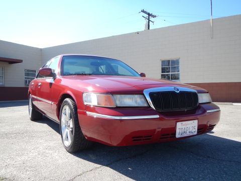 2002 Mercury Grand Marquis - Front view of a red 2002 Mercury Grand Marquis parked outdoors. The car has a chrome grille and a California license plate.
