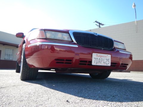 2002 Mercury Grand Marquis - Front view of a red 2002 Mercury Grand Marquis with a chrome grille and California license plate.