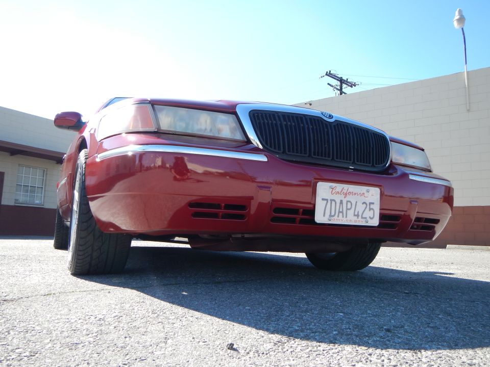 Red 2002 Mercury Grand Marquis with chrome grille and California license plate 7DAP425
