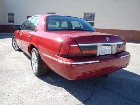 2002 Mercury Grand Marquis - This 2002 Mercury Grand Marquis features a custom paint job and aftermarket wheels, viewed from the rear.