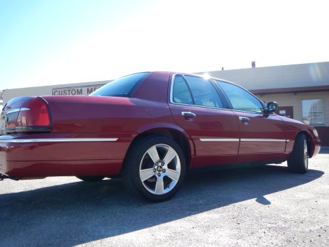 2002 Mercury Grand Marquis - A red 2002 Mercury Grand Marquis is shown from a 3q-front angle, aftermarket wheels and chrome trim.