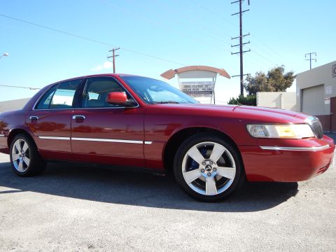 2002 Mercury Grand Marquis - A red 2002 Mercury Grand Marquis is shown from the front quarter angle, custom wheels.