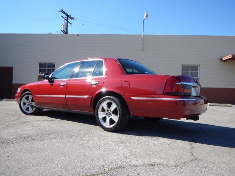 2002 Mercury Grand Marquis - A red 2002 Mercury Grand Marquis is shown from the rear passenger side, parked on asphalt.