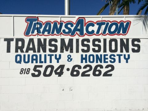 1997 Dodge 3500 - A sign advertises 'Transaction Transmissions' with a phone number and a promise of quality and honesty.