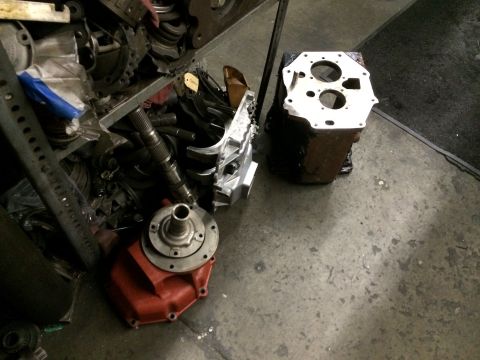 1997 Dodge 3500 - Various transmission parts, including a red housing and metal shafts, are laid out on a concrete floor.