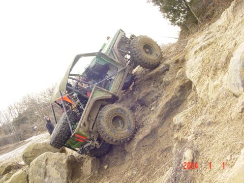 1992 Ford Bronco - An off-road vehicle is precariously positioned on a steep, rocky slope.