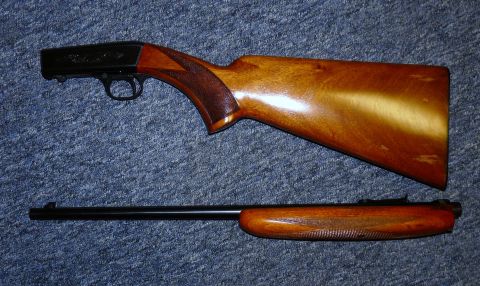 2006 Ford E350 - Disassembled shotgun receiver and barrel shown on a blue carpeted surface.