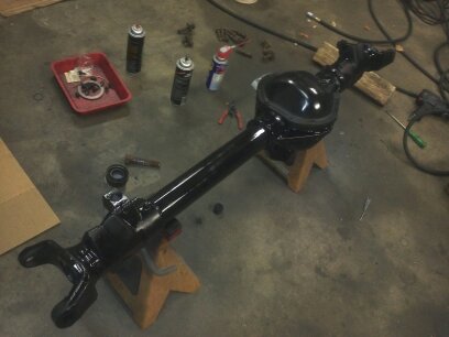 1995 Ford Bronco - Ford rear axle assembly undergoing maintenance or restoration, with various tools and supplies visible.