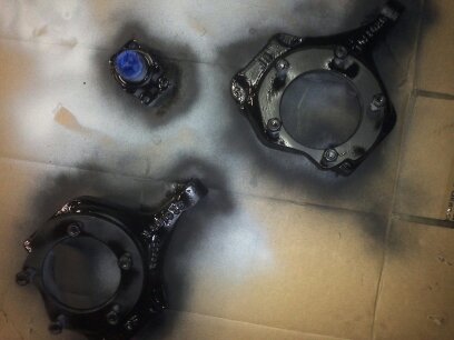 1995 Ford Bronco - Freshly painted brake components sit on a surface, awaiting reassembly.