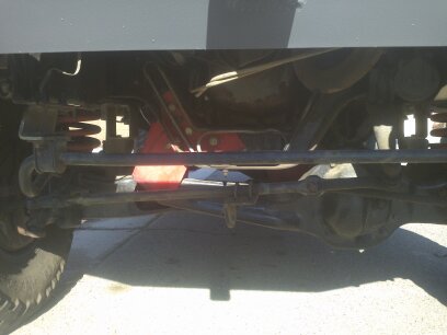 1995 Ford Bronco - Close-up view of the undercarriage of a vehicle, focusing on suspension and drivetrain parts.