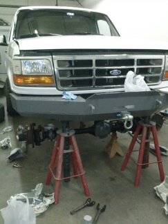 1995 Ford Bronco - Front end of a 1995 Ford Bronco undergoing work, supported by jack stands.