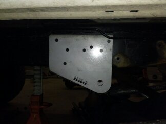 1995 Ford Bronco - A close-up view of a metal bracket, likely a vehicle part, with visible text indicating the manufacturer.