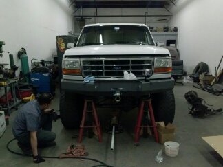 1995 Ford Bronco - A 1995 Ford Bronco is being worked on in a garage, elevated on jack stands.