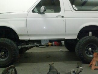 1995 Ford Bronco - 1995 Ford Bronco with custom suspension modifications visible from the side.